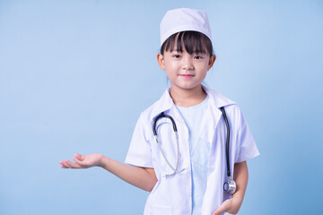 Image of Asian child wearing doctor uniform on blue background