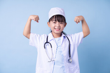 Image of Asian child wearing doctor uniform on blue background