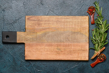 New cutting board and spices on dark background