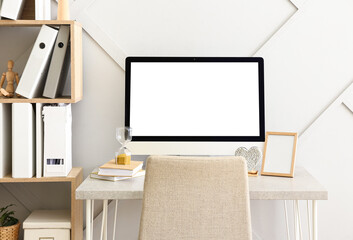 Interior of room with comfortable workplace and shelf  with folders near light wall