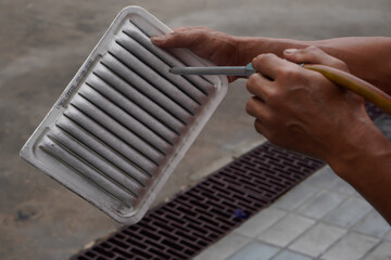 Mechanic blowing air on the car air filter