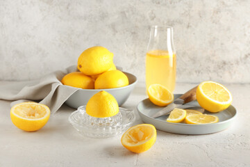 Composition with ripe lemons and juicer on light background