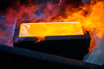 Hot gold ingot chills in casting form in shielding gases
