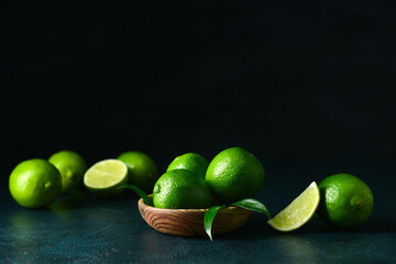 Bowl of fresh limes on dark background
