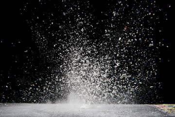 Explosion of white powder isolated on black background. 