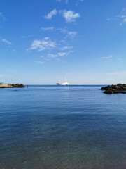 The largest sailing yacht in the world, an eight-deck motorsailer on the Mediterranean coast against a blue sky with beautiful clouds.