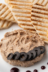 Liver meat pate spread with grilled white bread on a wooden background, breakfast, close-up, no people, selective focus, pasticcio, pastete
