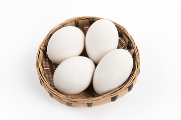 goose eggs in a rattan basket on white background
