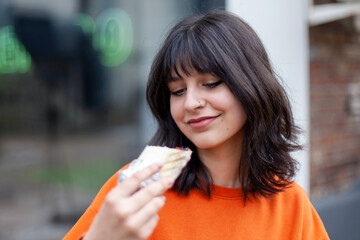 A young smiling girl holds vegetarian rolls.