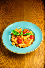 Italian recipe Pasta tortilloni with green pea, mint leaves, cheece, smoked bacon and cheese. Top view, blue background