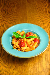 Italian recipe Pasta tortilloni with green pea, mint leaves, cheece, smoked bacon and cheese. Top view, blue background