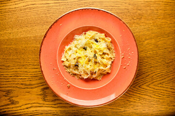 Italian recipe Pasta tortilloni with green pea, mint leaves, cheece, smoked bacon and cheese. Top view, blue background