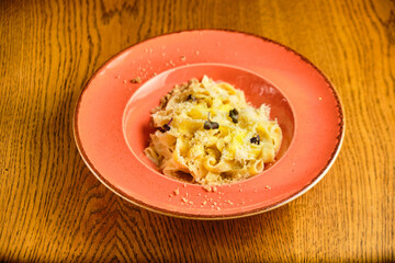 Italian recipe Pasta tortilloni with green pea, mint leaves, cheece, smoked bacon and cheese. Top view, blue background