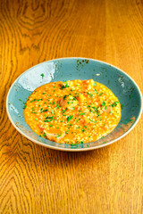 Tomato Risotto on a white restaurant plate.