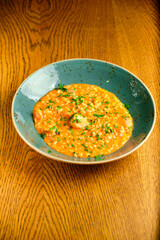 Tomato Risotto on a white restaurant plate.