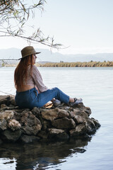 Traveler girl sitting in the middle of the water