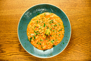Tomato Risotto on a white restaurant plate.