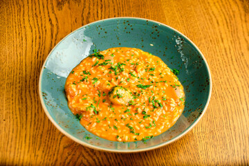 Tomato Risotto on a white restaurant plate.