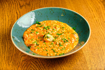 Tomato Risotto on a white restaurant plate.