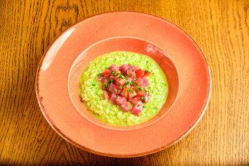 Green Risotto on a white restaurant plate.