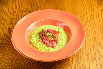 Green Risotto on a white restaurant plate.