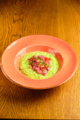 Green Risotto on a white restaurant plate.