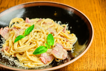 Italian recipe Pasta tortilloni with green pea, mint leaves, cheece, smoked bacon and cheese. Top view, blue background