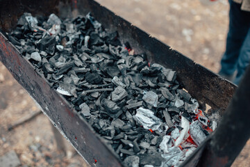 Burning charcoal in the grill. Outdoor recreation. Cooking outside on an open fire.j