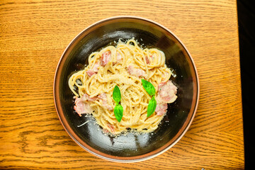 Italian recipe Pasta tortilloni with green pea, mint leaves, cheece, smoked bacon and cheese. Top view, blue background