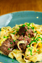 Italian recipe Pasta tortilloni with green pea, mint leaves, cheece, smoked bacon and cheese. Top view, blue background