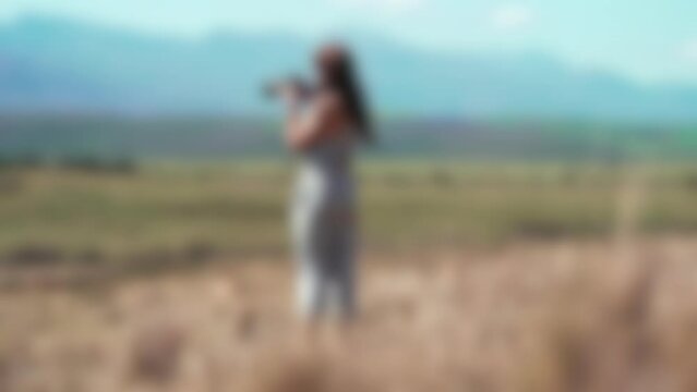 Blurry Slow motion footage of a female photographer taking photos out in the field alone
