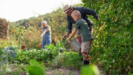 Grandfather with grandson working in garden together. - Powered by Adobe