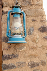 old stone wall with blue lantern out of focus with grain