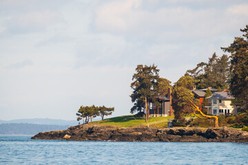 A rocky beach point on the sea at sunset with trees