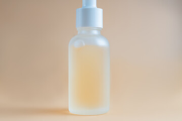 Face serum in a glass package, bottle on a white neutral background. treatment for skin with oils, vitamins and collagen. Packaging of cosmetic beauty product.