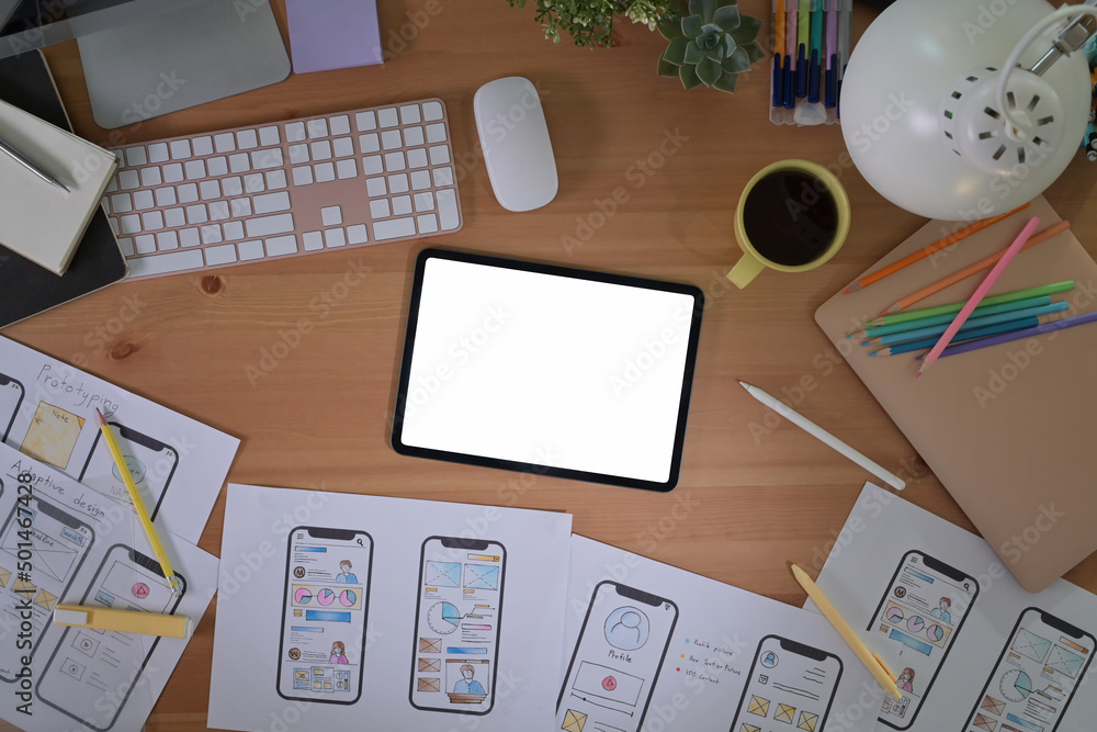 Poster top view digital tablet and mobile app wireframe sketches on wooden table.