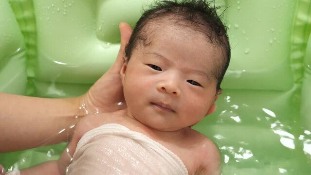 Newborns take a bath at 0 months of age