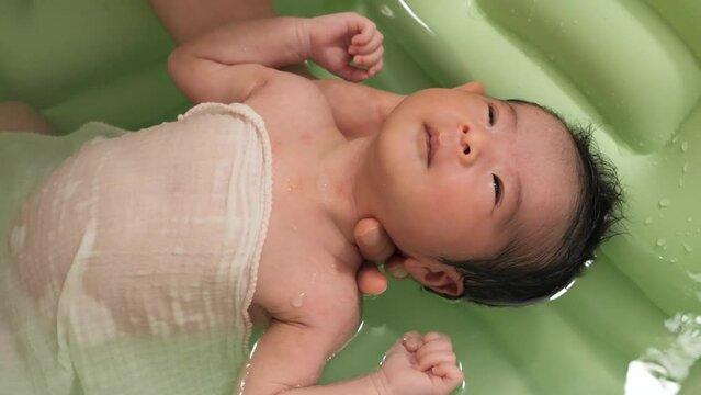 Newborns take a bath at 0 months of age