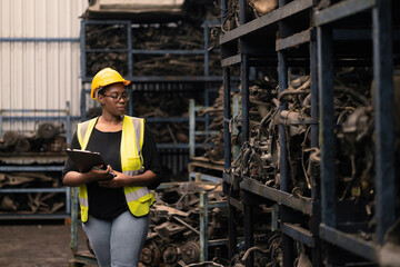 black african women worker working inspect check stock inventory of machine part warehouse