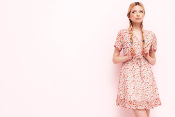 Young beautiful smiling female in trendy summer red dress. Sexy carefree blond  woman posing near wall in studio. Positive model having fun. Cheerful and happy