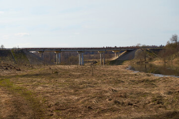 Fototapeta na wymiar Spring landscape. A road bridge over the river