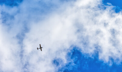 an airplane flying in a blue cloud in a blue sky