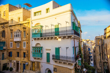 Fototapeta na wymiar Traditional Maltese architecture. Old historical part of La Valetta with narrow streets and wooden balconies, La Valetta, Malta