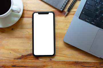 Top View Work space office desk, mockup empty screen smartphone on wooden table. with clipping path, with blank space screen for advertising text.