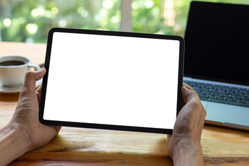 mock up empty screen tablet, businessman working on his tablet with blank space screen for advertising text on wood desk in office