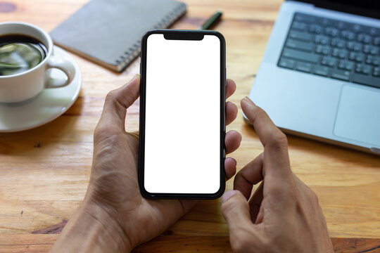 man hand using smartphone In the office Screen blank with clipping path ,Top view mockup image of male holding mobile phone with empty white screen