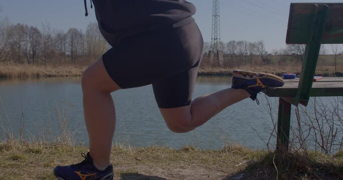 A curvy girl does a workout of the muscles of the priests and legs. She squats on one leg using a bench. Reducing body size. CZ, Kladno, Armenska, 22.3.22. 