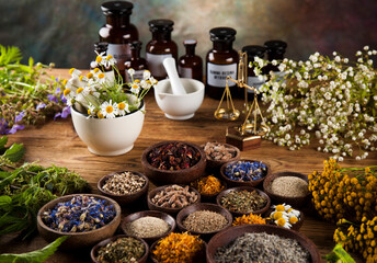 Natural medicine, herbs, mortar on wooden table background