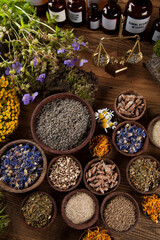 Healing herbs on wooden table, mortar and herbal medicine