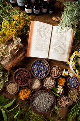 Book and Herbal medicine on wooden table background